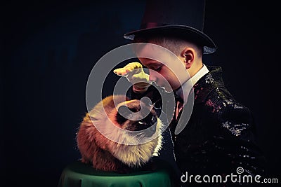 Cat and Magician kid illusionist boy in hat. mystery magical black background Stock Photo