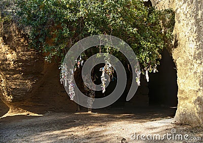 Catacomb entrance with tree and tied pieces of cloth Stock Photo