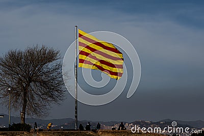 Catalan flag fluttering in the wind with a cloud of pollution and Barcelona in the background Stock Photo