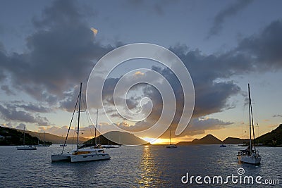 Catamarans and sailboats at anchor in Soper`s Hole at sunset, West End, Tortola, BVI Stock Photo