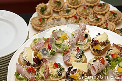 Catering, company food service, plates full of fresh tasty food and small appetizers, banquet concept, lots of small sandwiches Stock Photo