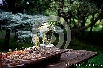 Catering for the wedding Banquet.Canapes, small sandwiches on paper and wooden surface Stock Photo