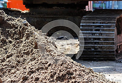 caterpillar excavator and a pile of sand on building construction site to repair road Stock Photo
