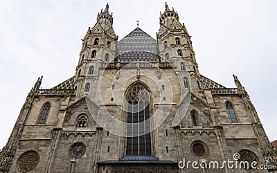 Cathedral church medieval architecture building huge facade front side foreshortening from below on gray cloudy sky background in Stock Photo