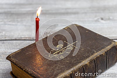 Catholic bible and red church burning candle on wooden background Stock Photo