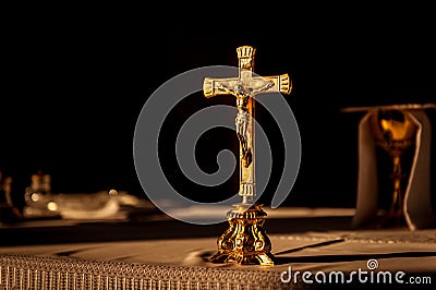 Catholic cross on altar in church lit by sunlight Stock Photo