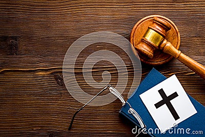 Catholic cross - catholicism religion concept - near gavel and book on wooden desk top view. Religious conflict concept Stock Photo