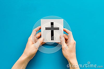 Catholic cross sign in hands - catholicism religion concept - on blue background top view copy space Stock Photo