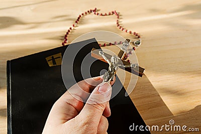 Catholic paraphernalia. Crucifixion of Jesus, Bible and Holy Rosary Stock Photo