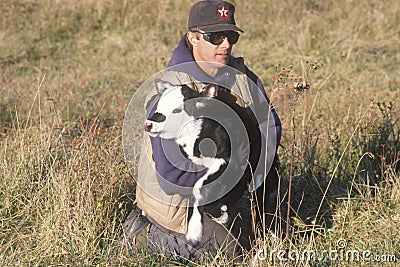 Cattle farmer holding calf in Bourbon, MO Editorial Stock Photo