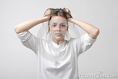 Cauasian woman in panic in studio. halding her head. She is holding her head with hands. Stock Photo