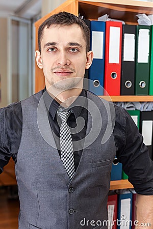 Caucasian accounting manager standing in front of cabinet with documentation folders Stock Photo