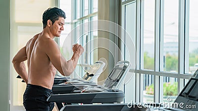 Athletic man doing running exercise on treadmill in gym and fitness center Stock Photo