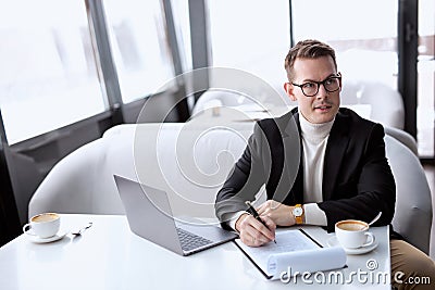 Caucasian attentive businessman alone in restaurant, waiting for investors or business partners Stock Photo