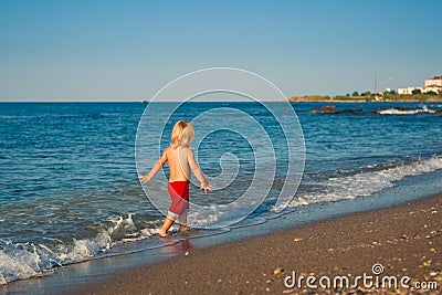 Caucasian baby boy walk on the beach Stock Photo