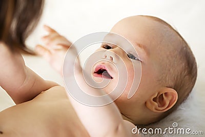 Caucasian baby reaching out for mother. Stock Photo