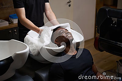 Caucasian barber dries clients hair with a soft towel Stock Photo