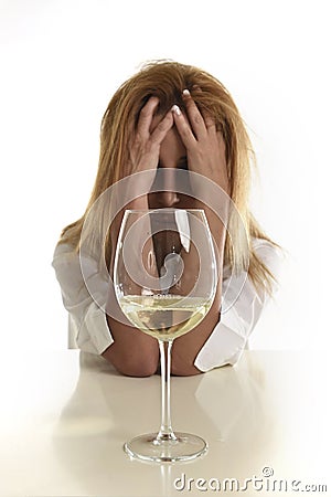 Caucasian blond wasted and depressed alcoholic woman drinking white wine glass desperate drunk Stock Photo