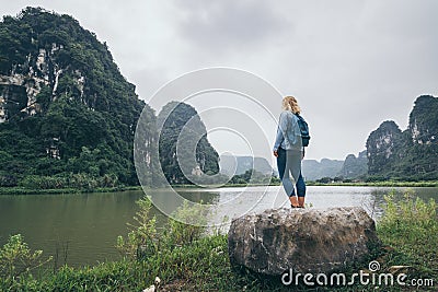 Caucasian blonde woman overlooking limestone mountains in Ninh Binh province, Vietnam Stock Photo