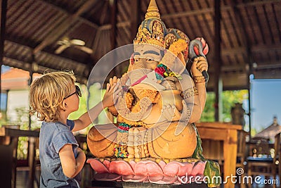 Caucasian boy high-five Ganesha. Meeting Western and Eastern culture concept. oriental and occidental. Traveling to Asia Stock Photo