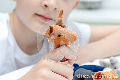 A caucasian boy playing finger puppets, toys, dolls - figures of animals, heroes of the puppet theatre put on fingers of human Stock Photo