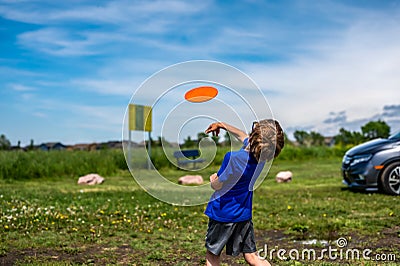 Caucasian child playing disc golf and making the first toss Stock Photo