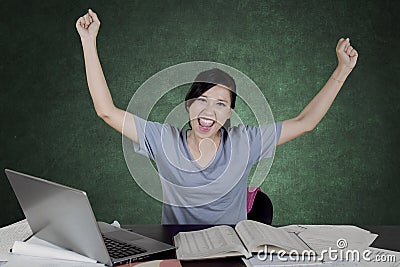 Caucasian college student lifting hands in the classroom Stock Photo