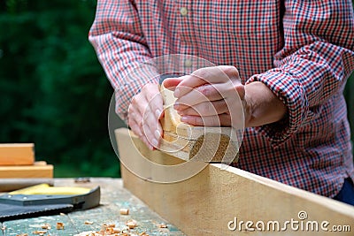 Caucasian craftswoman working in her workshop using carpentry plane. Woodworking concept Stock Photo