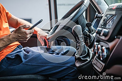 Delivery Truck Driver Browsing Internet Using His Smartphone Stock Photo