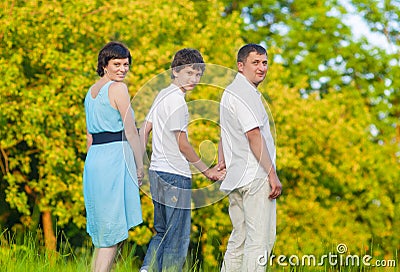 Caucasian Family of Three Spending Time Together Embraced in Summer Park Stock Photo