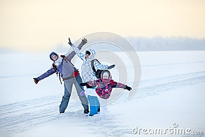 Caucasian family from three women standing with raising hands on lake, winter hiking Stock Photo