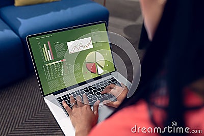 Caucasian female entrepreneur analyzing infographic business report over laptop at office Stock Photo