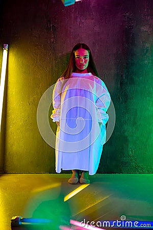 Caucasian female inclusive model posing on studio background in neon light Stock Photo