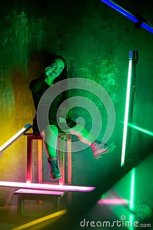 Caucasian female inclusive model posing on studio background in neon light Stock Photo