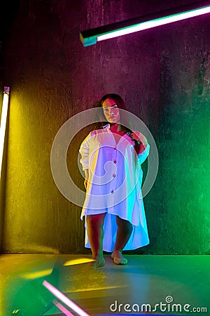 Caucasian female inclusive model posing on studio background in neon light Stock Photo