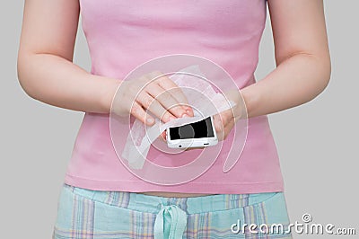 Caucasian girl wipes a white smartphone with disinfectant wipe Stock Photo