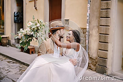 Interracial wedding couple. Wedding in Florence, Italy. Caucasian groom circling African-American bride. Stock Photo