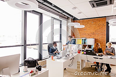 Caucasian handsome office worker is swearing at his African boss Stock Photo