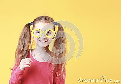 Caucasian happy smiling child girl in yellow glasses on empty space yellow background Stock Photo