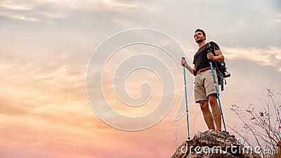 Caucasian hiker feel happy with his success to achieve climbing up mountain with sunset view Stock Photo