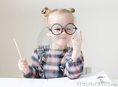 Caucasian little girl with round glasses. Little teacher Stock Photo