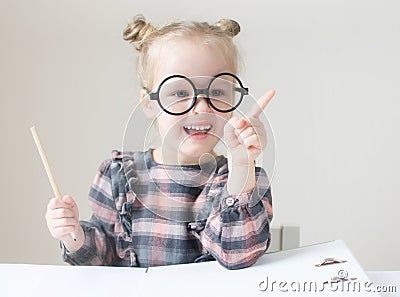 Caucasian little girl with round glasses. Little teacher Stock Photo