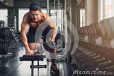 Caucasian male athletic bodybuilding workout trainer having dumbbell weightlifting in gym and fitness club, selective focused Stock Photo