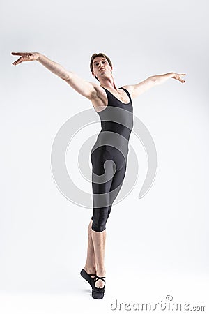 Professional Caucasian Male Ballet Dancer Flexible Athletic Man Posing in Black Tights in Ballanced Dance Pose With Hands Aligned Stock Photo
