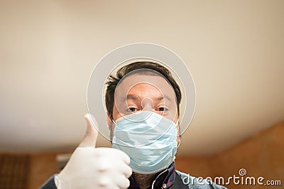 Caucasian male at home during quarantine. Wearing a flu mask and sanitary gloves Stock Photo