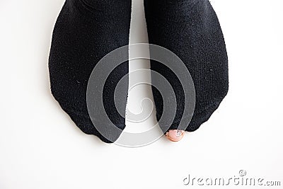 Caucasian male toe sticking out of worn out short nylon black plain socks with hole top view Stock Photo