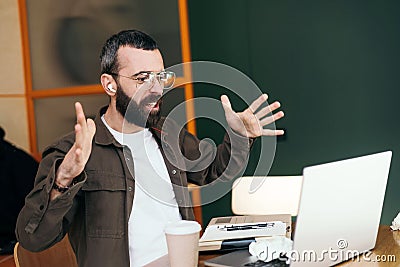 Caucasian man in a cafe is in an online conversation via webcam, appearing distressed and angry Stock Photo