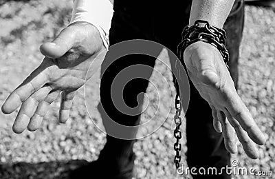 Caucasian man hand in rusty chains , shallow depth of field, conceptual image of crime Stock Photo