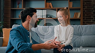 Caucasian man parent father psychologist talk to little cute kid girl teach small child of youth generation. Friendly Stock Photo