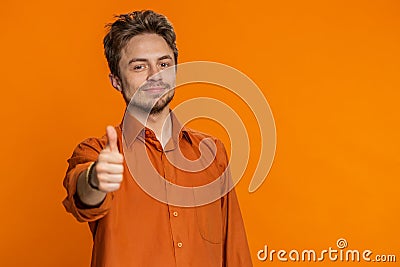 Caucasian man raises thumbs up agrees gives positive reply recommends advertisement likes good idea Stock Photo